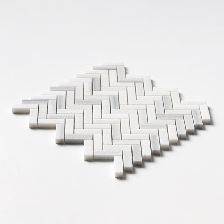 Close-up of Carrara Neptune Honed Herringbone Marble Mosaic showing fine Italian marble texture.
